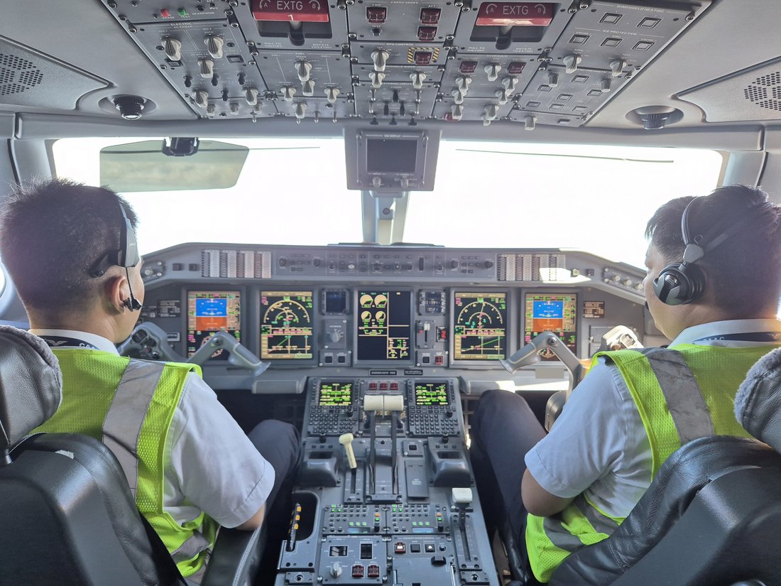 Airline flight deck in cruise — two pilots operating a scheduled flight across the region